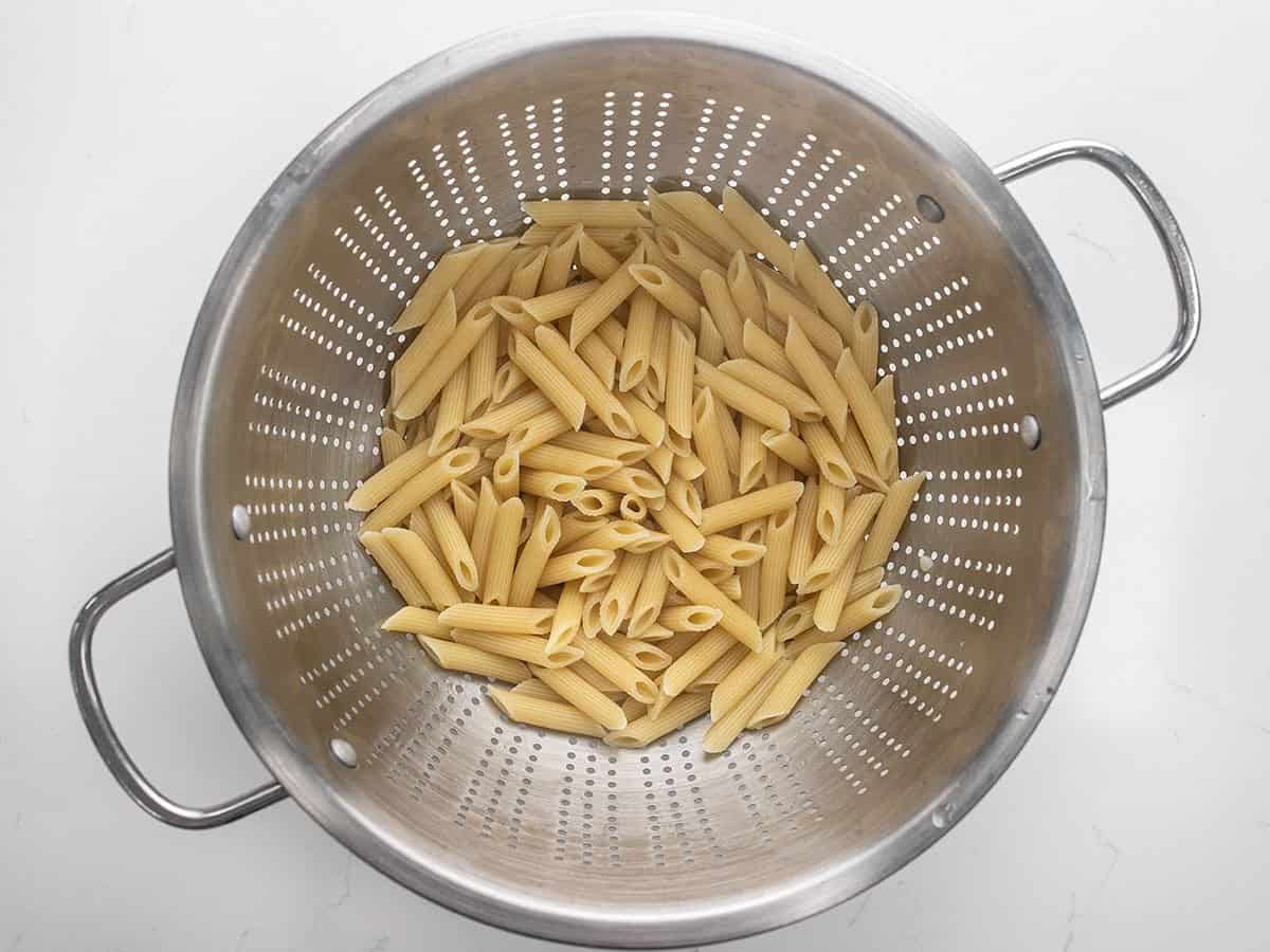 cooked penne in a colander.