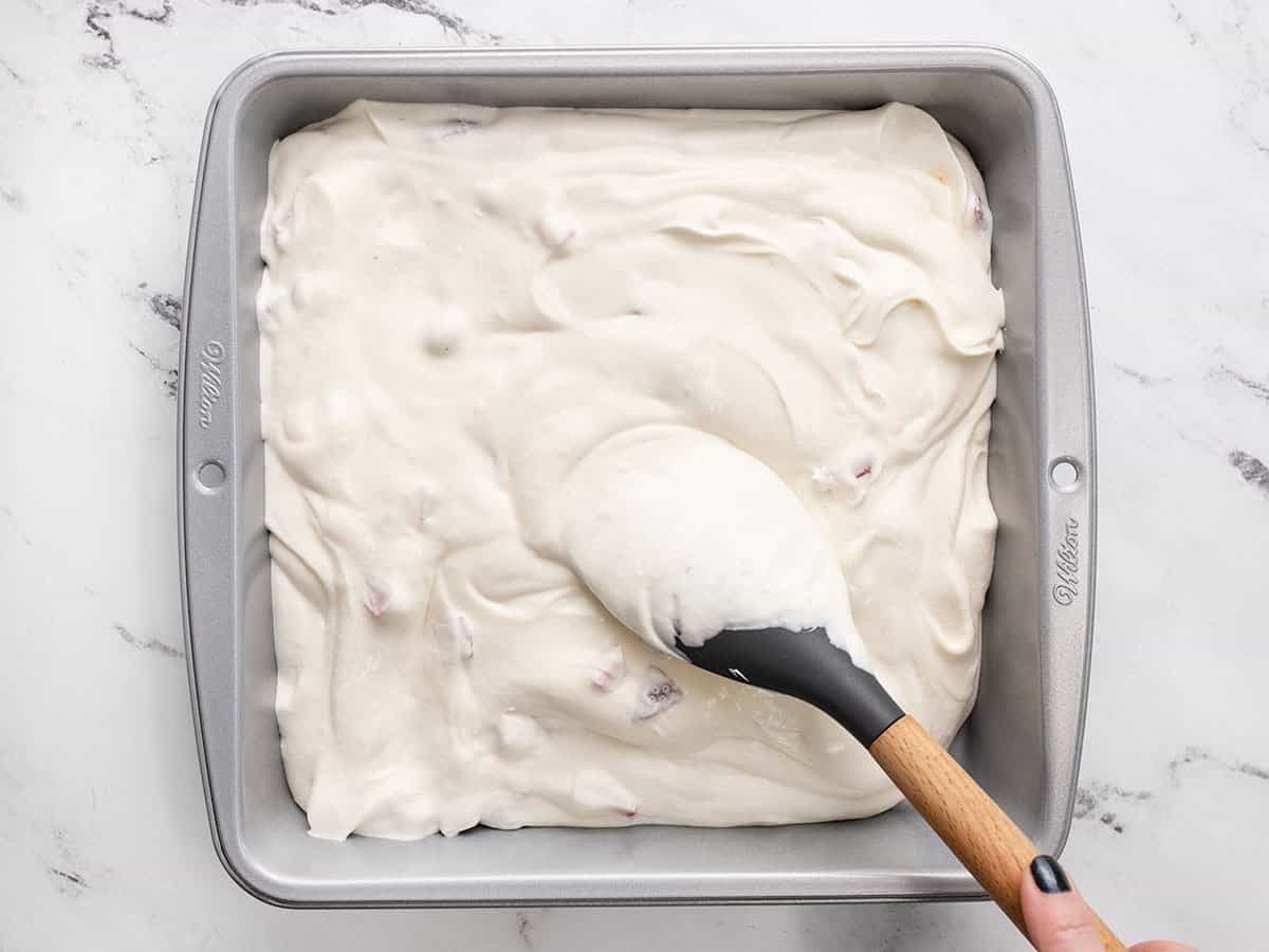 The ice cream base is spooned into a freezer-safe container.