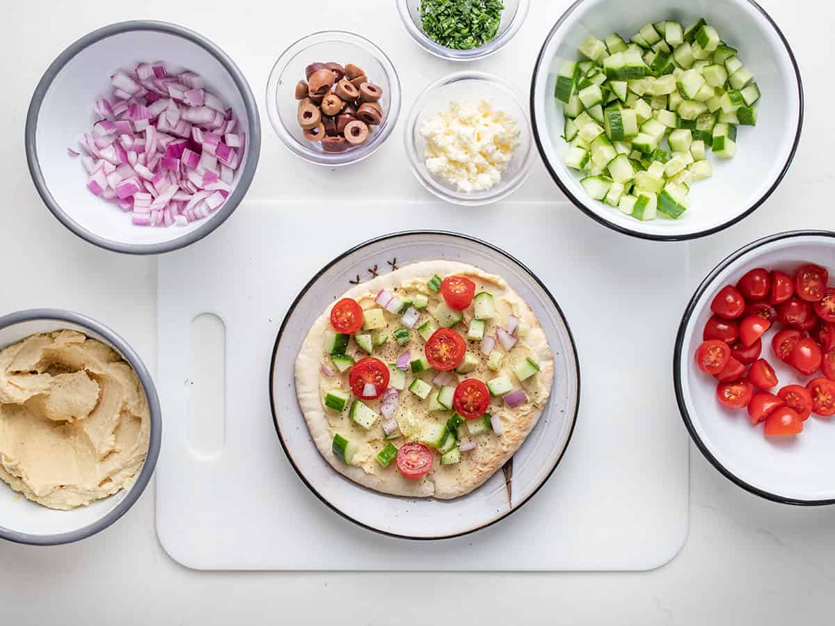 Pita topped with chopped cucumber, onion, and tomatoes.