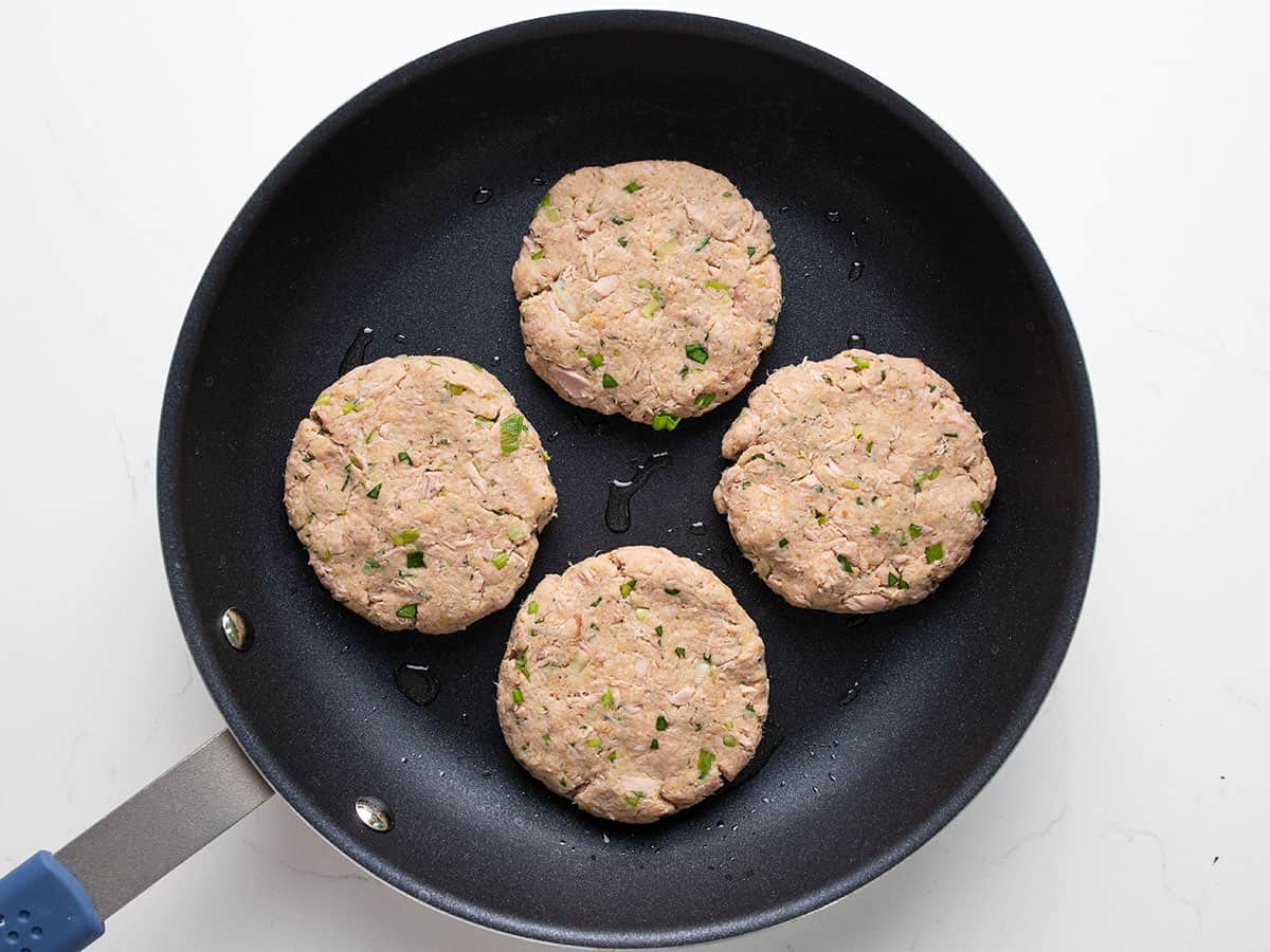 Raw tuna cakes shaped and in the skillet.