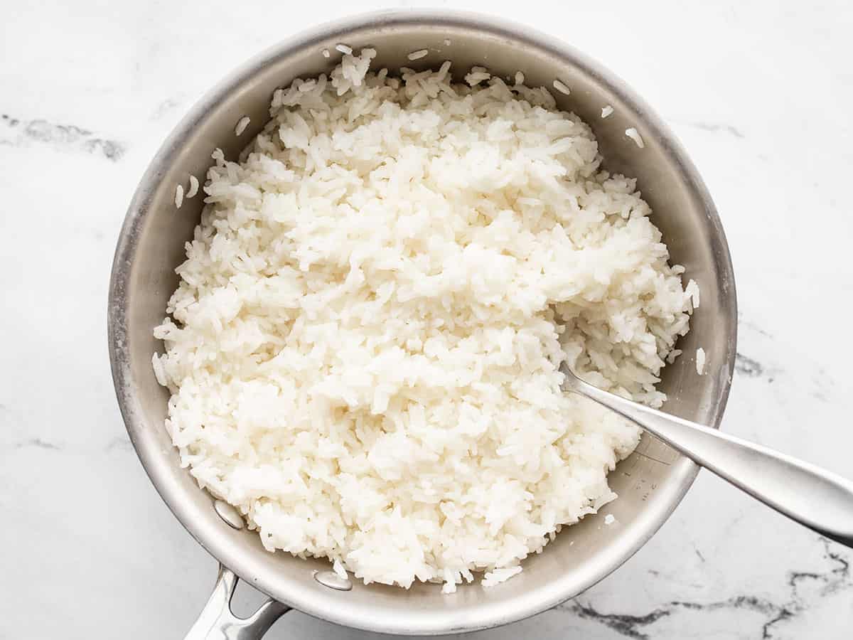 Rice in the pot being fluffed with a fork.