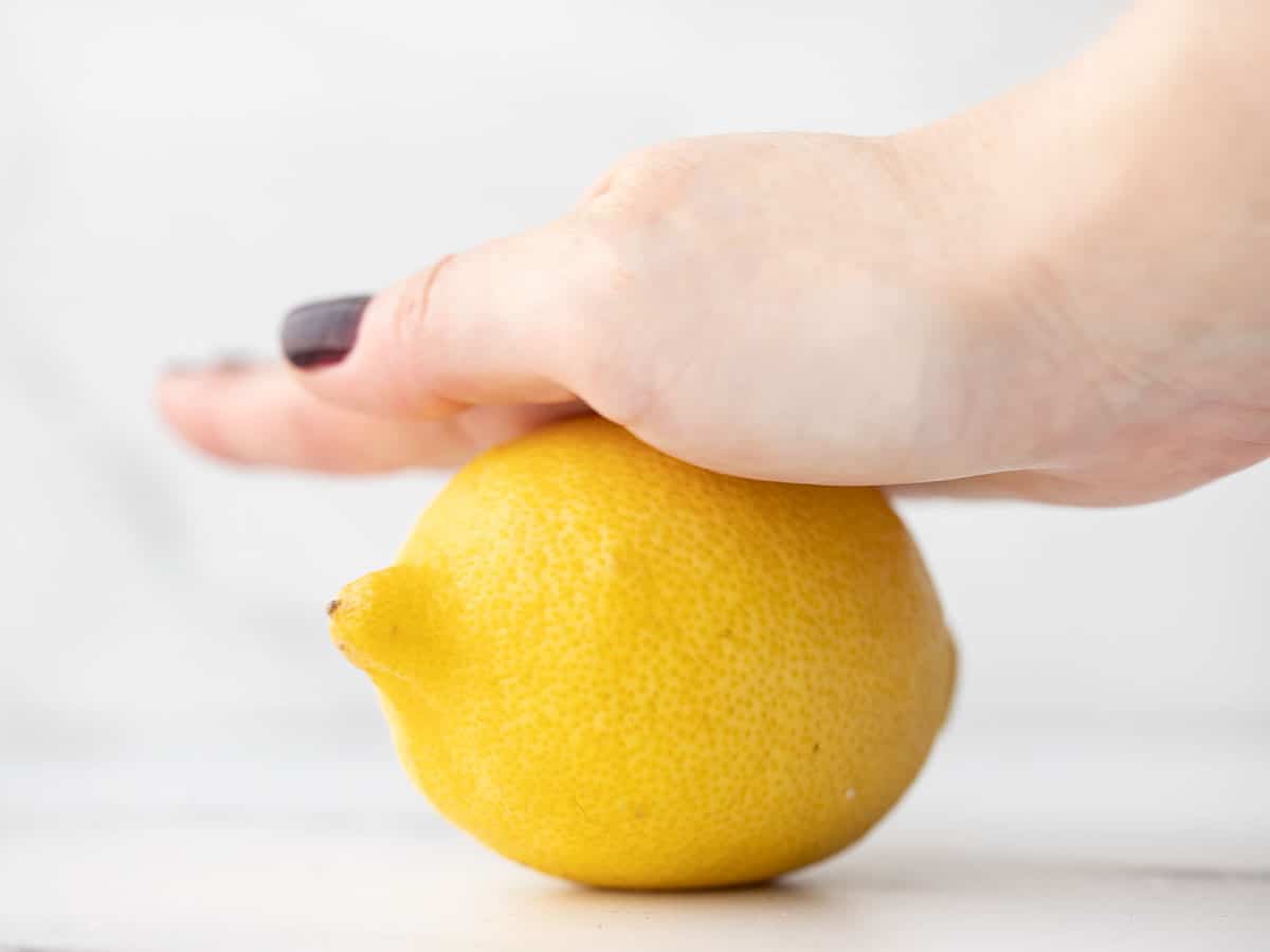 A lemon being rolled on a countertop