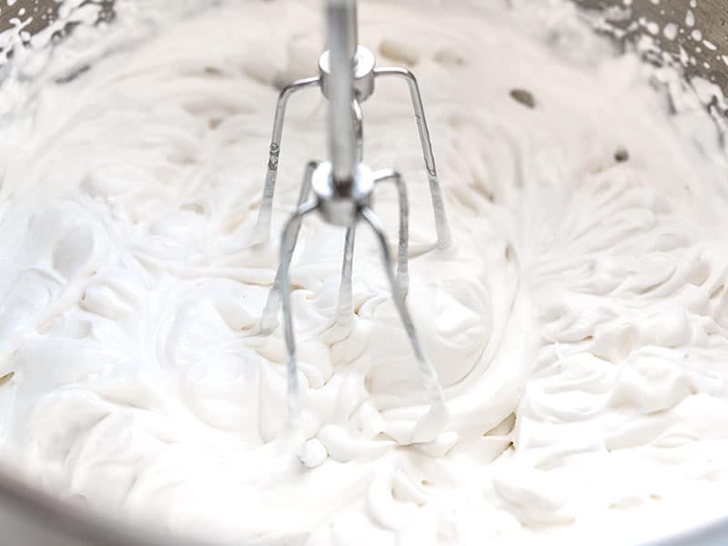 Whipped cream in a bowl, close up, with beaters still in the cream