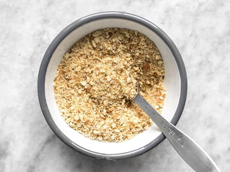Finished Italian flavored breadcrumbs in a bowl with a measuring spoon