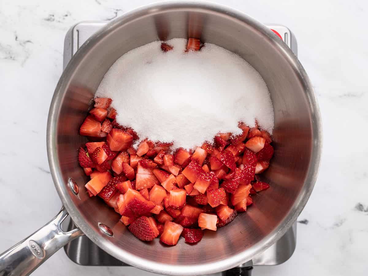 Chopped strawberries and sugar in a saucepot. 
