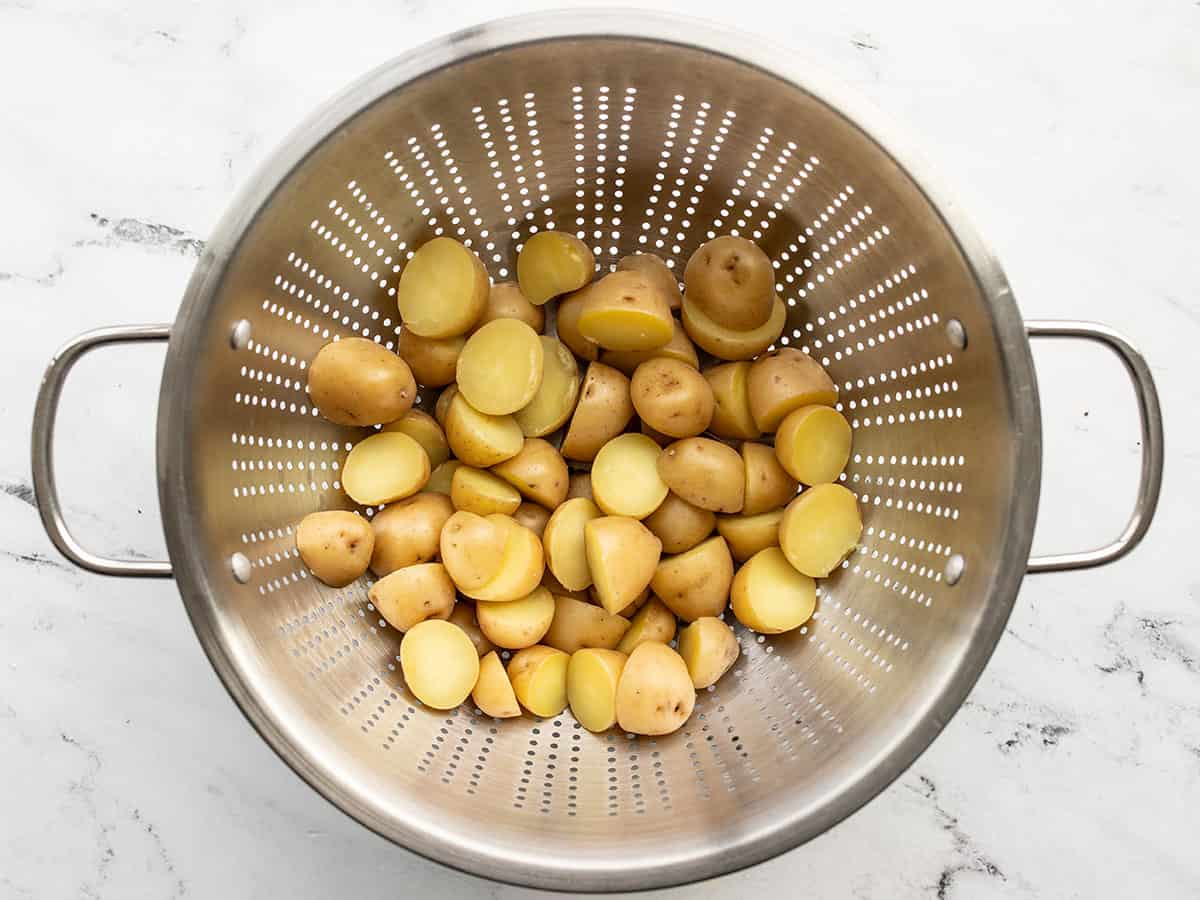 Boiled potatoes draining in a colander.