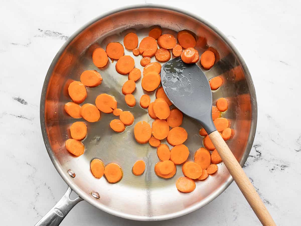 Carrots being sautéed in a skillet