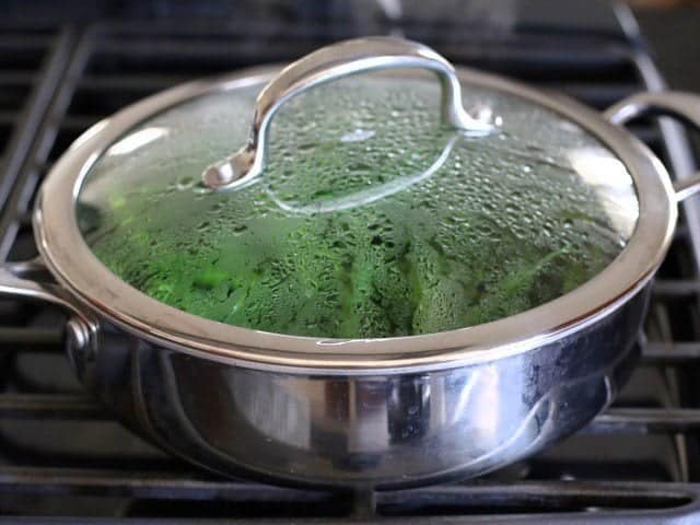 Green beans in the skillet with steam on the lid