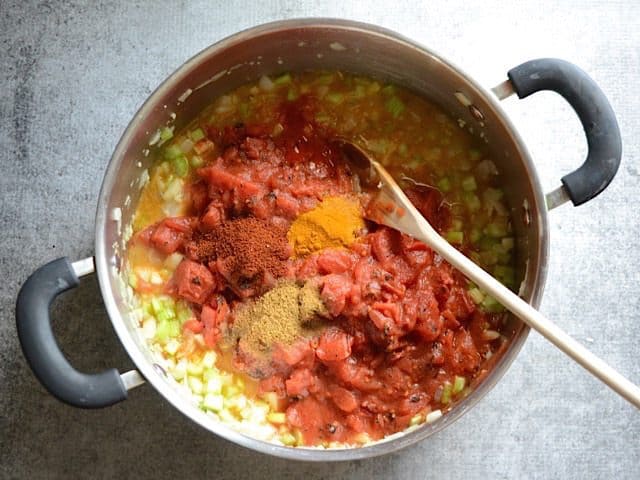 Tomatoes and Spices added to pan of sauted onion, garlic and celery
