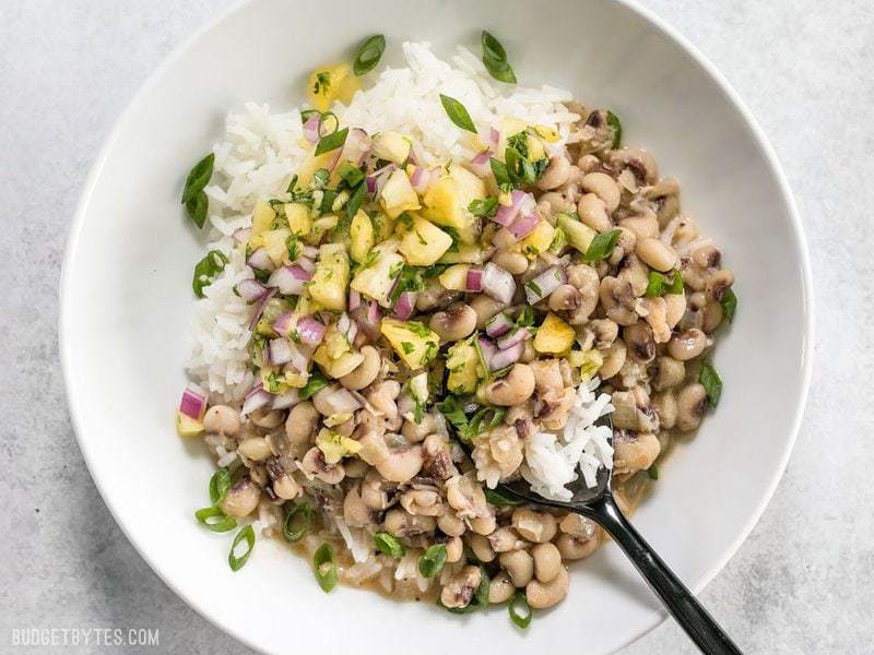 These rich and spicy Coconut Jerk Peas are super simple to make and pair brilliantly with a sweet and vibrant pineapple salsa.