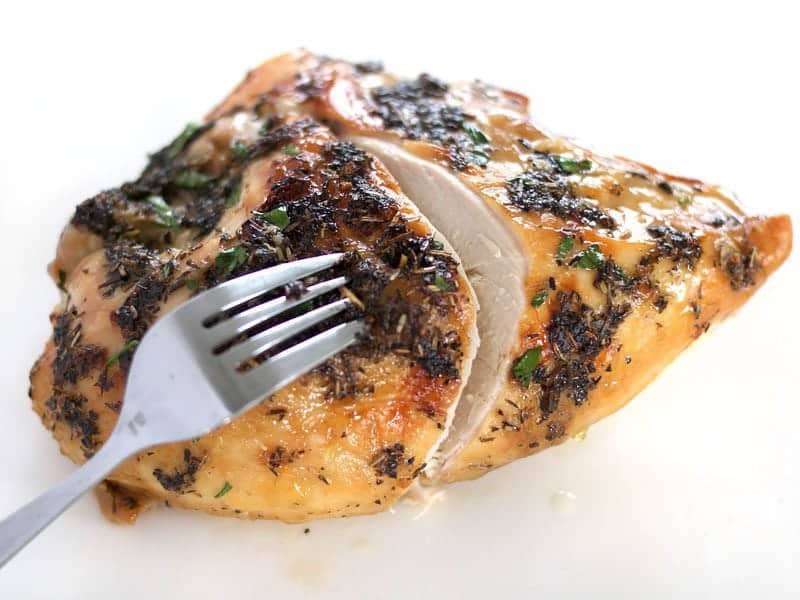 Herb Roasted Chicken Breasts just sliced open, a fork pulling it apart