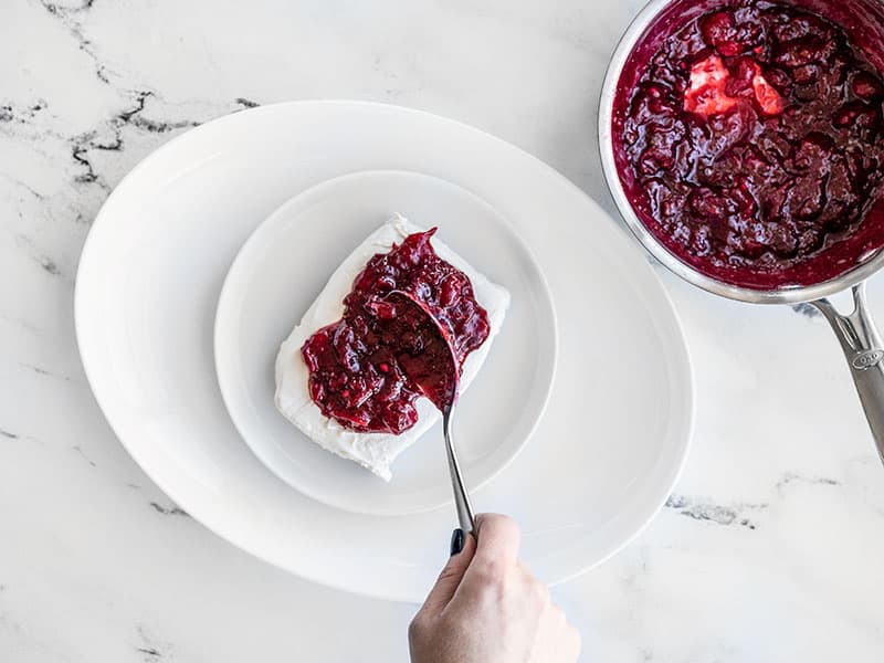 Cranberry Sauce being spooned onto cream cheese