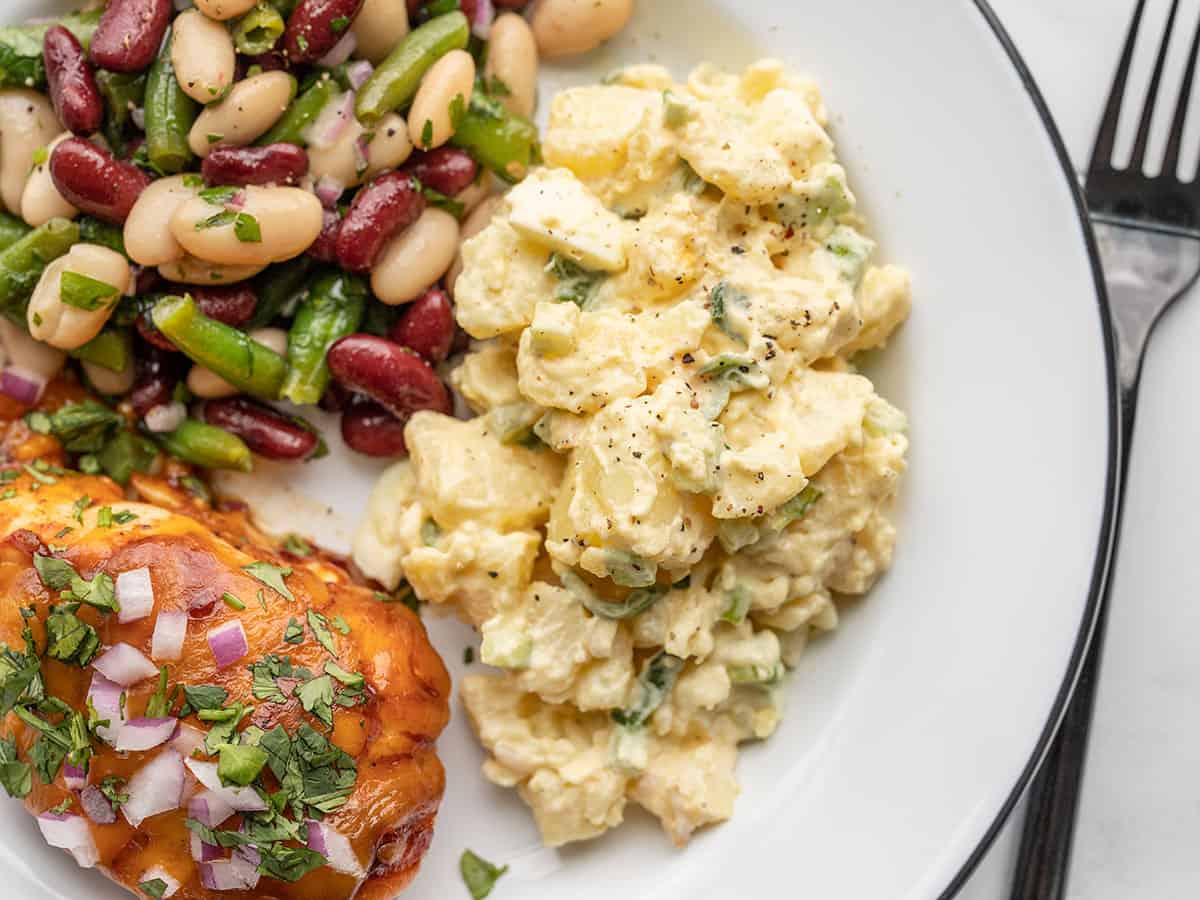 potato salad on a plate with bbq chicken and three bean salad