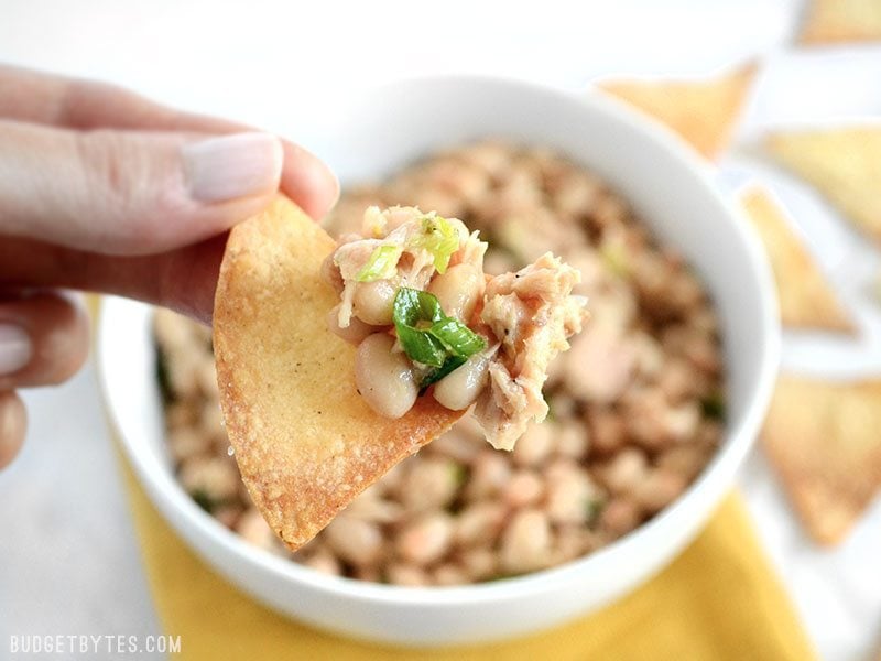 Close up of a pita chip with tuna and white bean salad on it 