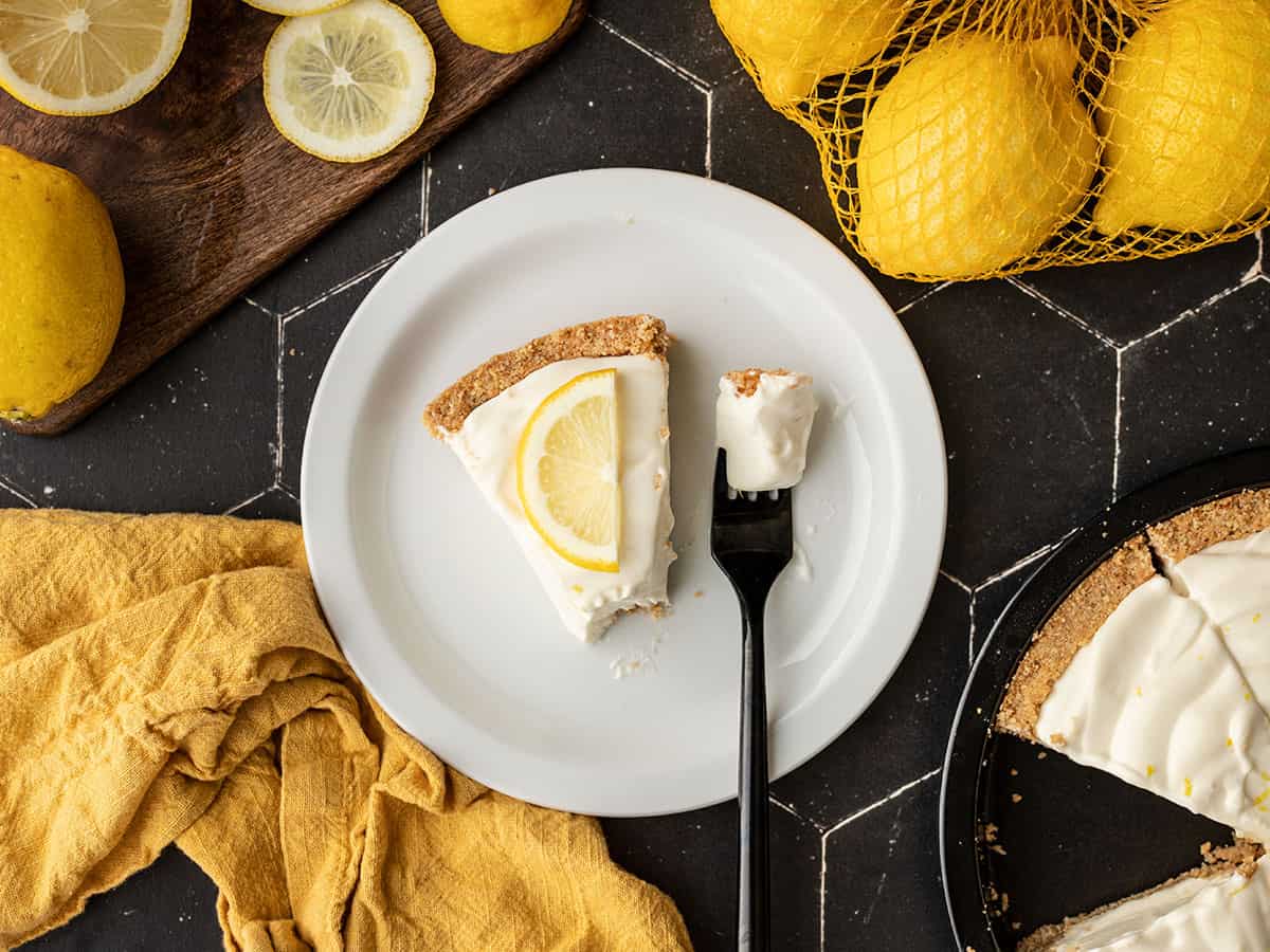 a piece of lemon cream pie on a plate with a fork on the plate