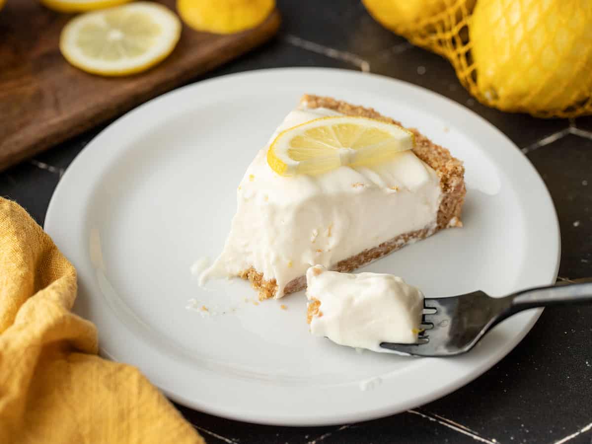 Side view of a slice of lemon cream pie with a fork