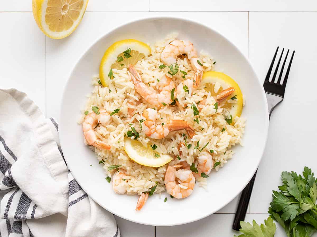 Lemon garlic shrimp and rice on a plate with a fork on the side