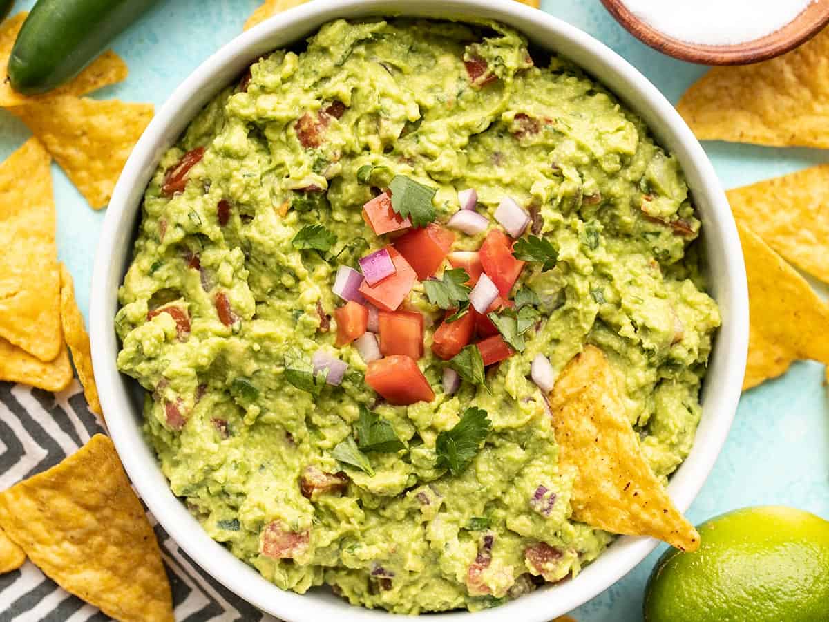 close up of guacamole in the bowl with a chip.