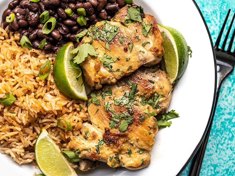 Easy Cilantro Lime Chicken on a plate with black beans and taco rice
