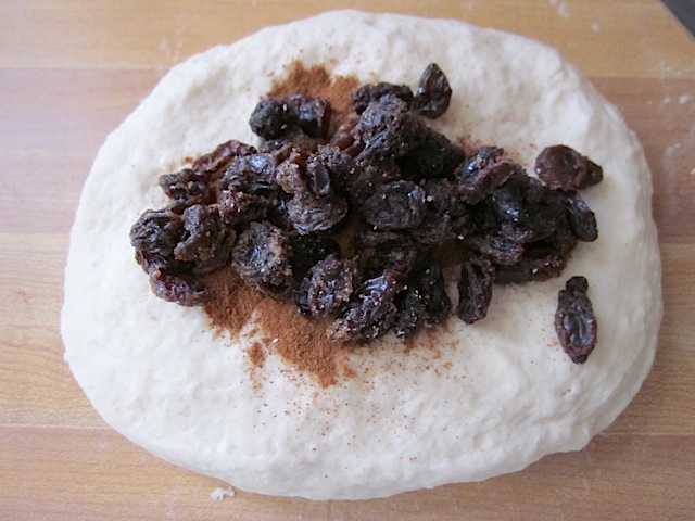 ball of dough with cinnamon and raisins on top 