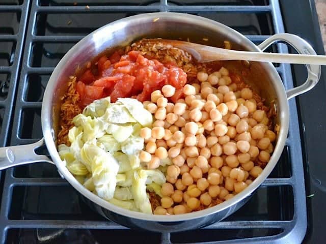 Add Tomatoes Chickpeas and Artichokes to the skillet