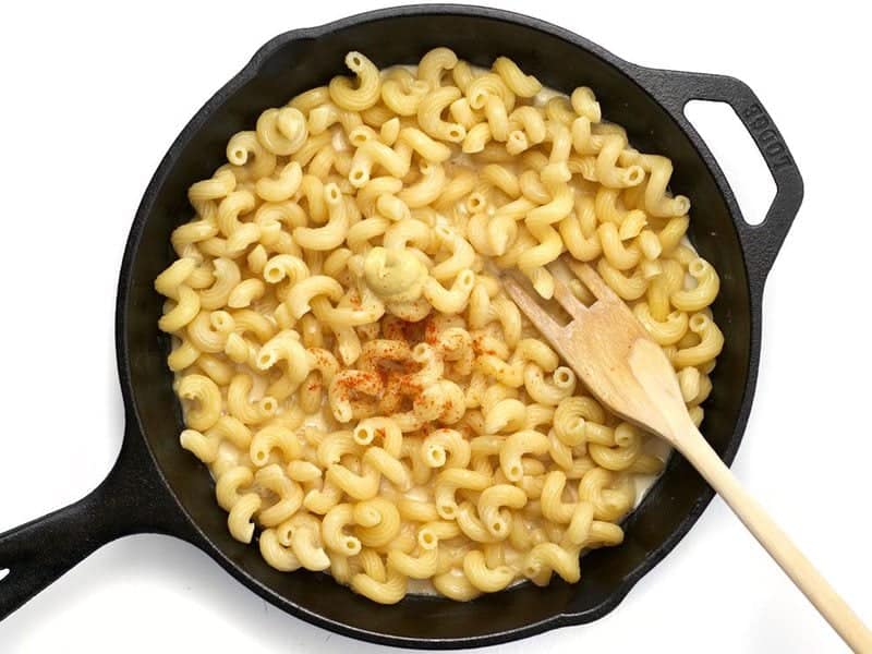 Dijon and Cayenne added to cast iron skillet with pasta and evaporated milk