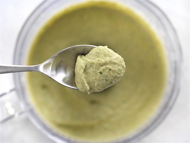 Parsley Scallion Hummus on a spoon over the food processor