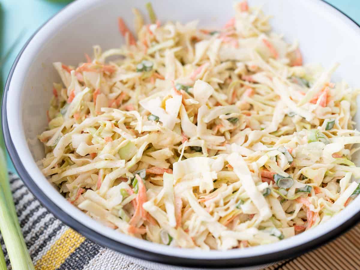 Side view of a bowl full of cumin lime coleslaw