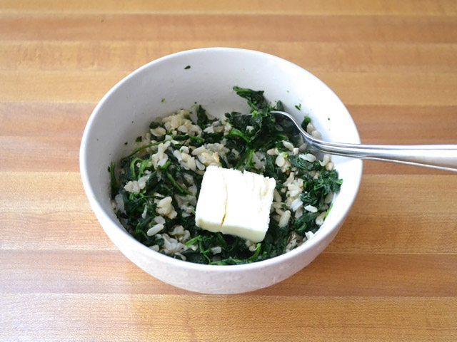 Seasoning and butter added to Spinach and Rice