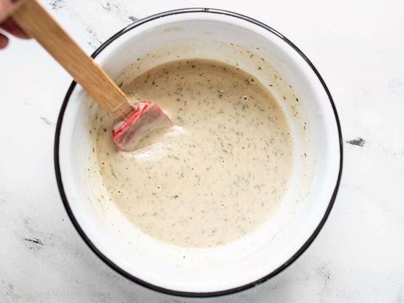 Lemon Dill Tahini Dressing in the bowl with a red spatula