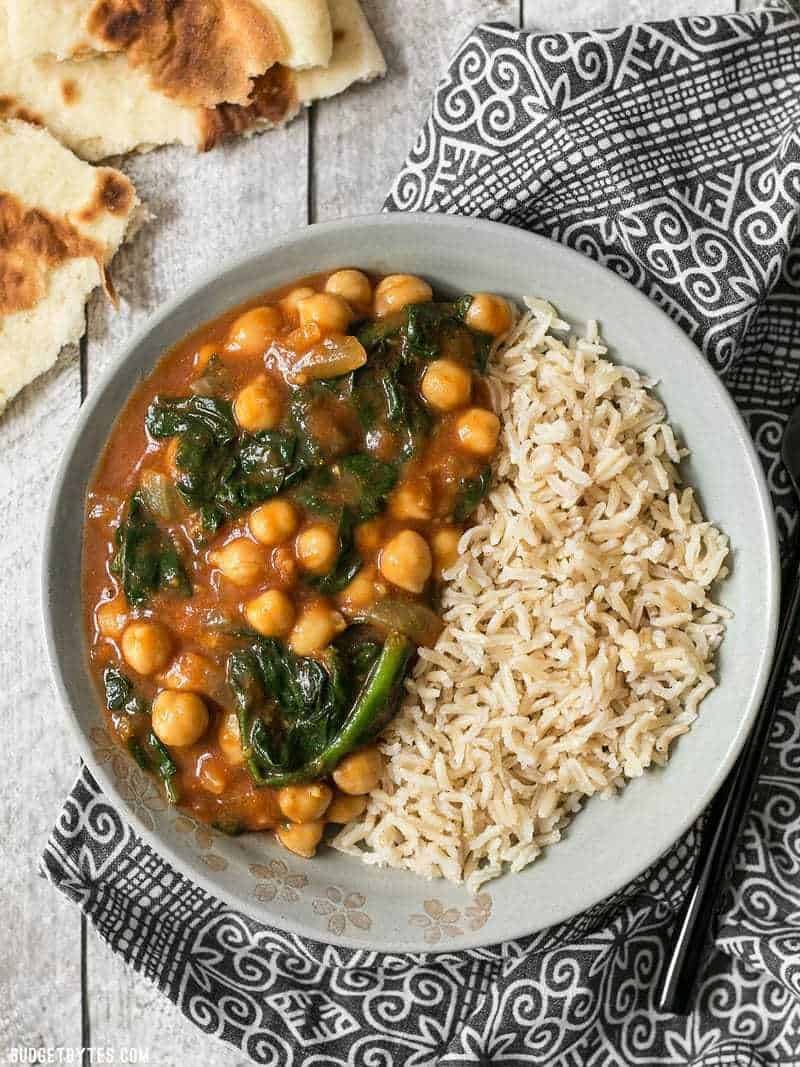 A bowl full of Curried Chickpeas with Spinach and brown basmati rice.