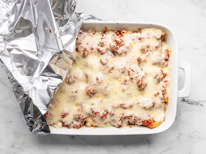 Baked ziti with melted cheese and foil peeled back