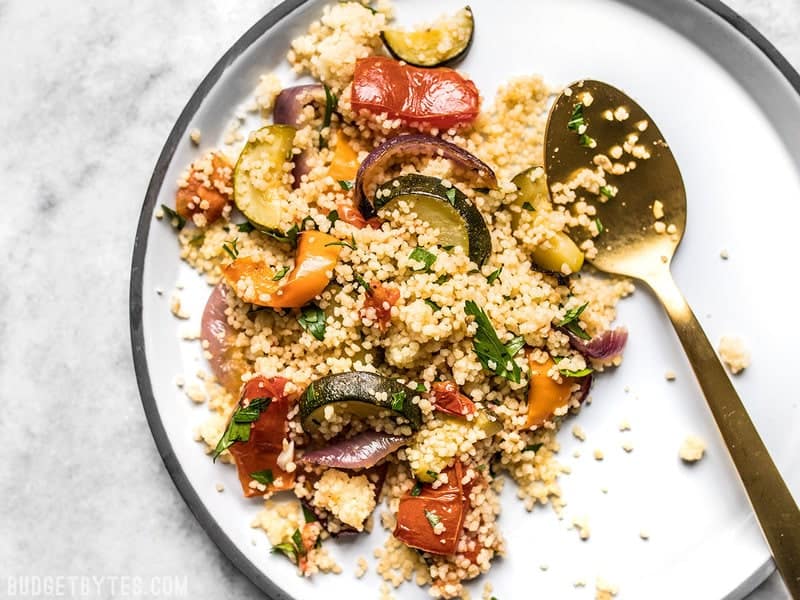 A plate with a few scoops of Roasted Vegetable Couscous and a golden spoon