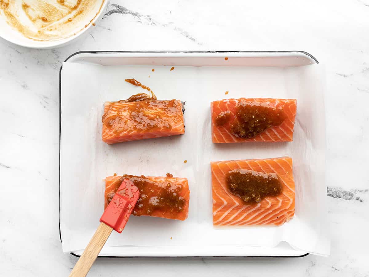 Glaze being spread onto salmon portions