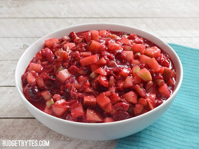 Side view of a bowl of Crunchy Cranberry Sauce, blue napkin on the side 