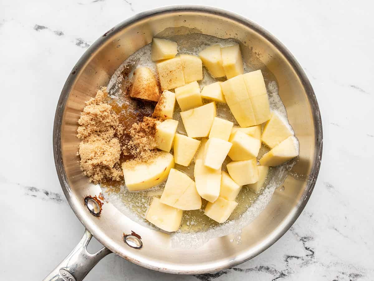 Chopped apples in a skillet with brown sugar, butter, and cinnamon