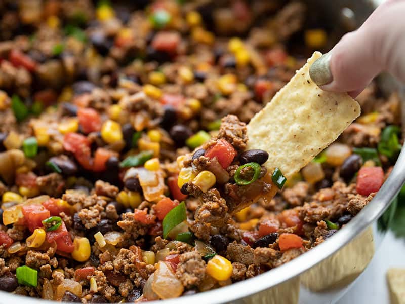 Close up of some turkey taco skillet being scooped up by a tortilla chip