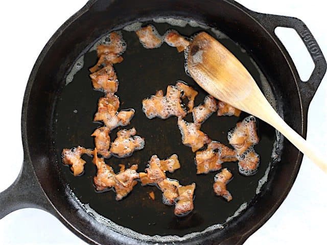 Bacon being cooked in a cast iron skillet