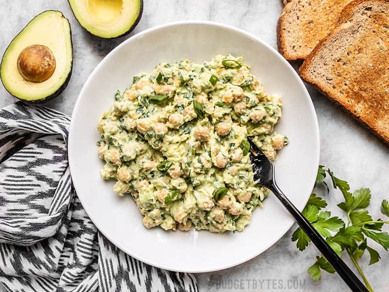 A bowl of Scallion Herb Chickpea Salad with toast and an avocado on the side