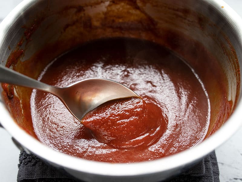 Close up of finished homemade bbq sauce in the pot with a spoon