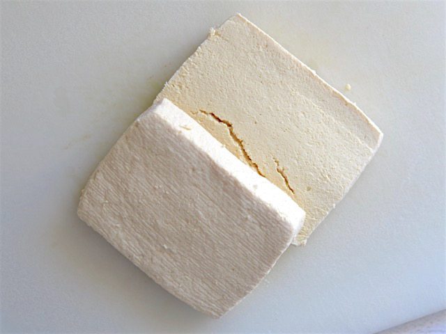 Block of tofu that has been squeezed and cut in half