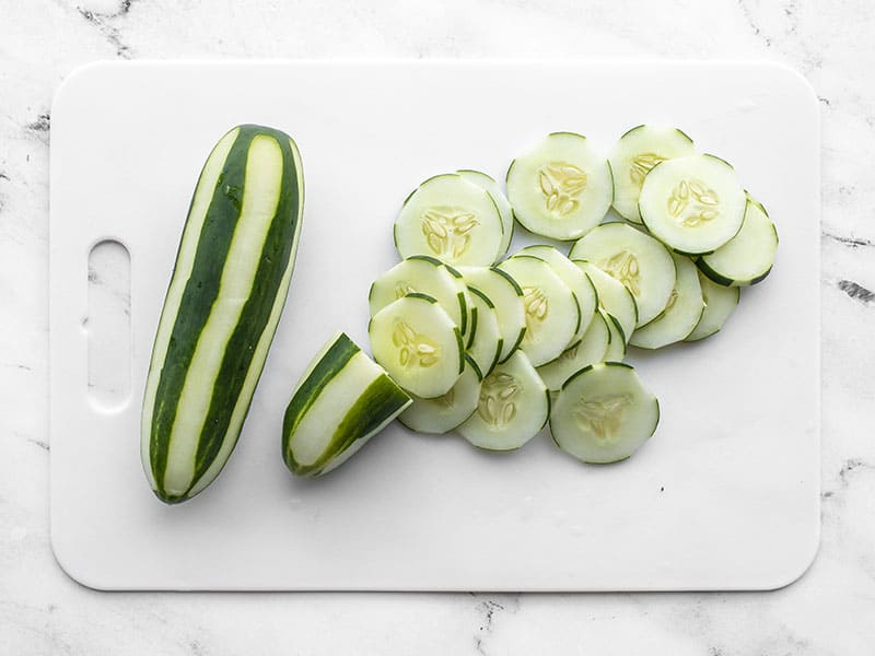 Two cucumbers, one mostly sliced