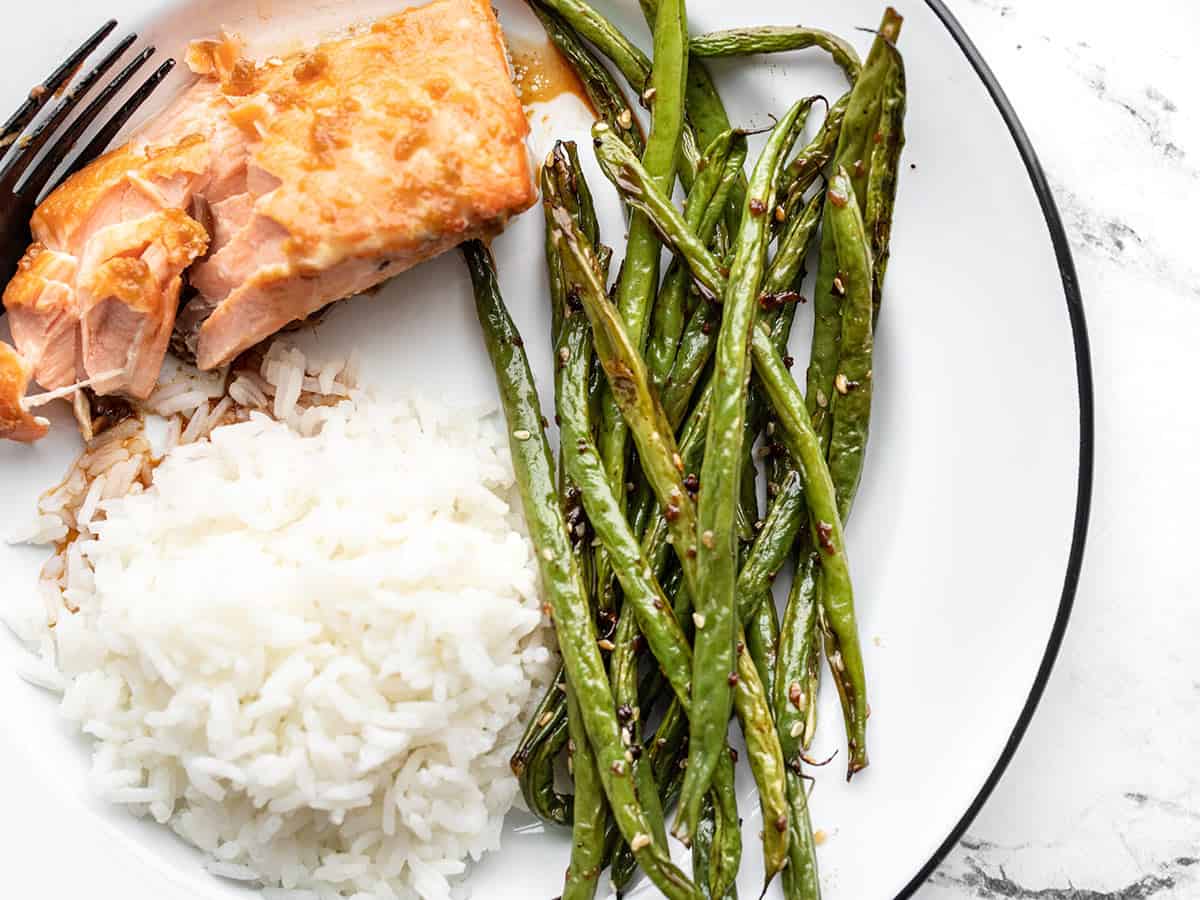 Sesame roasted green beans on a plate with salmon and rice