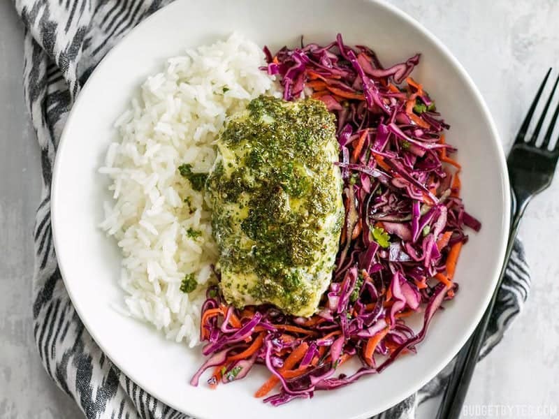 Finished Baked Chimichurri Fish on top of cooked rice and red cabbage slaw