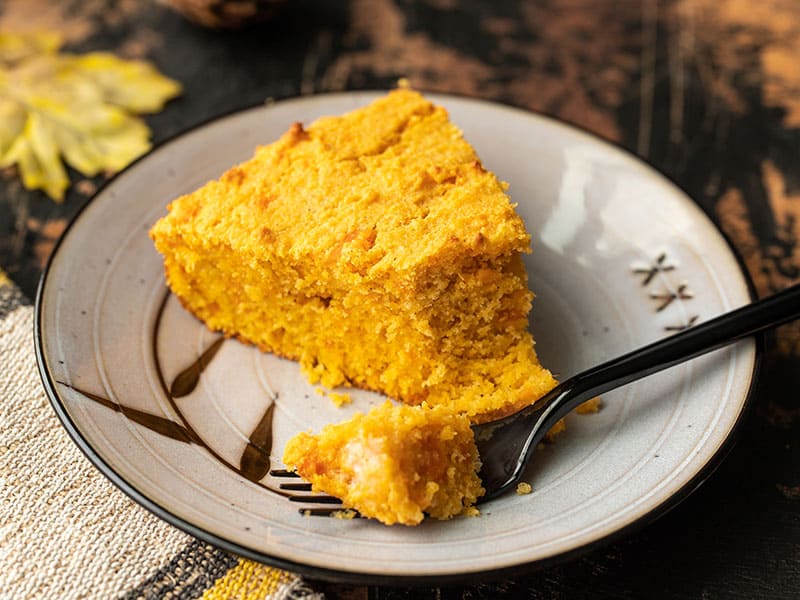 One slice of sweet potato cornbread on a plate with a fork