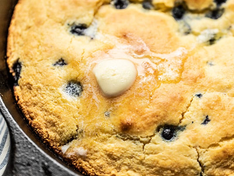 Close up of a pat of butter melting on the surface of Lemon Blueberry Cornbread